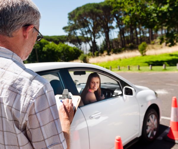 Learner driver girl with intstructor taking lessons